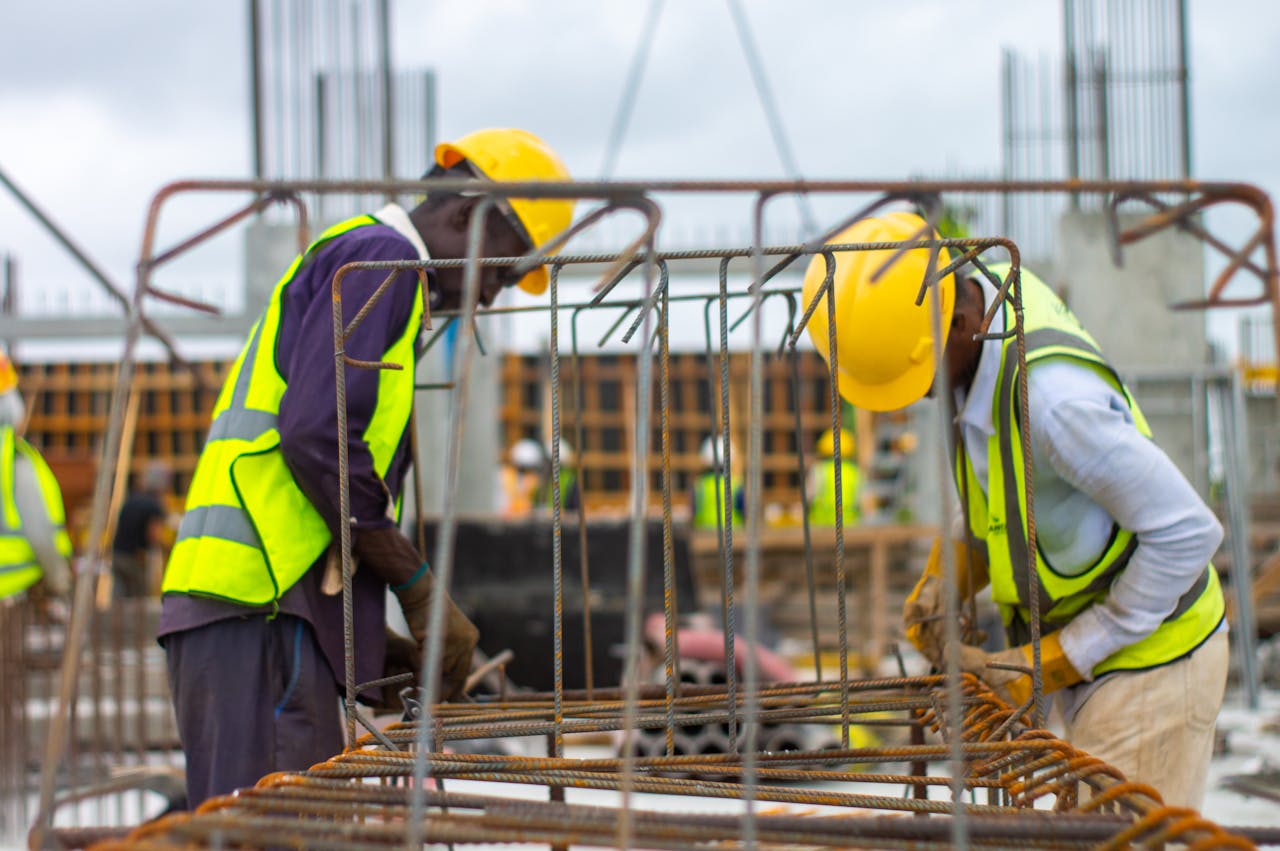 services-02 Construction workers with hard hats and safety vests working on site.